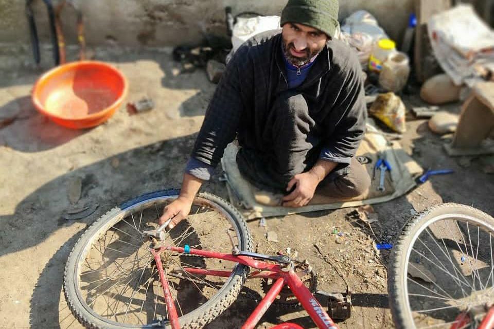 With paralyzed legs, Pulwama man starts cycle repairing to earn livelihood